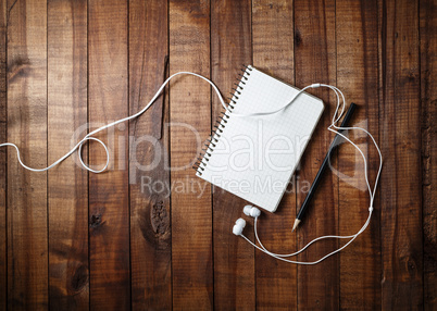 Notebook, pencil and headphones