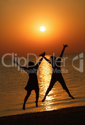 Girls jumping on a background of the rising sun