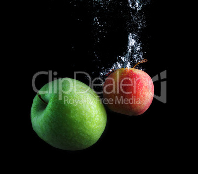 Green and red apples in water