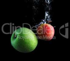 Green and red apples in water