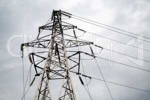 Electricity pylon against cloudy sky