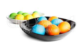 Colorful easter eggs on a black and white plates