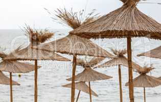 Straw umbrellas on sea background