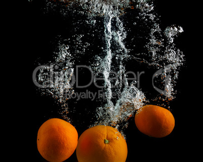 Oranges falling in water