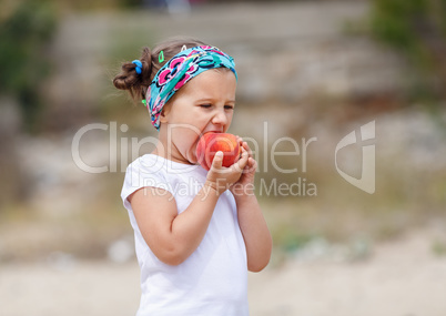 Baby girl eats a peach