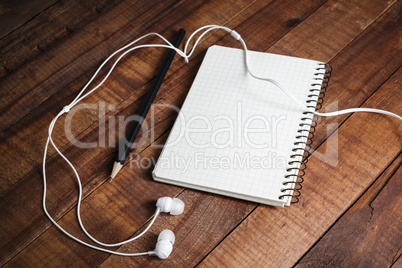 Notepad, pencil and headphones