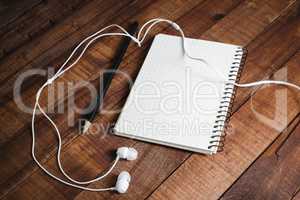 Notepad, pencil and headphones