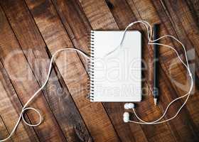 Notebook, pencil and headphones