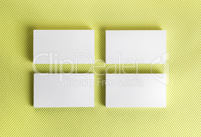 Blank business cards on green background.