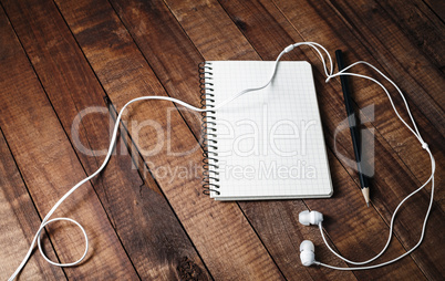 Notebook, pencil and headphones