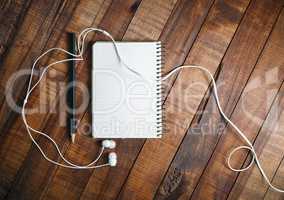 Notepad, pencil and headphones