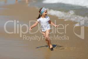 Child runs along the beach