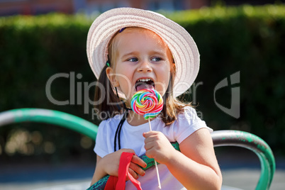 Little girl eating big candy
