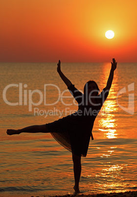 Girl dancing on the background of sunrise