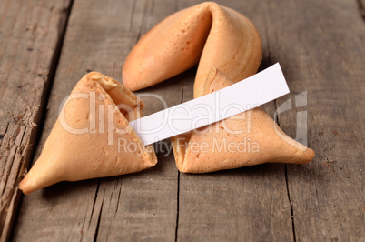 Cracked fortune cookie on a wooden table