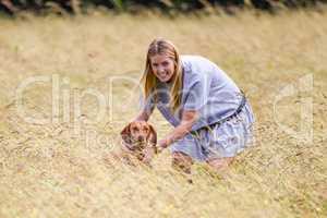 Woman holding Hungarian Vizsla in tall grass