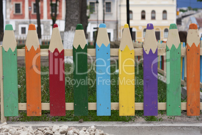 Wooden fence in the form of colorful pencils photo