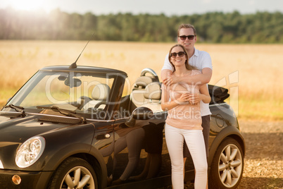 Liebespaar umarmt sich am Auto - Verliebtes Paar am Cabrio