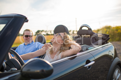 Mit dem Cabrio der Sonne entgegen - Verliebtes Paar lacht im Auto