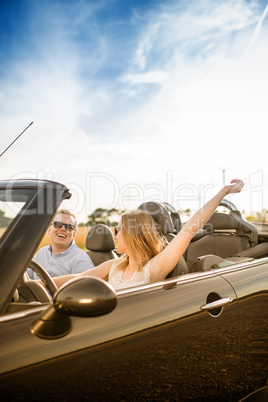 Pärchen im Cabrio schaut sich verliebt an - Endlich Urlaub