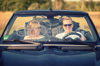 Frau schaut Mann im Auto verliebt an - Verliebt im Cabrio
