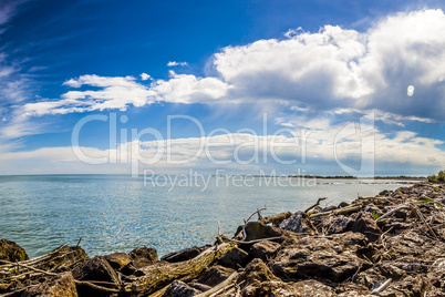 Rocks in front of the sea in a sunny but cloudy day