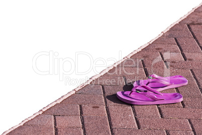 Purple flipflops on poolside in a sunny day