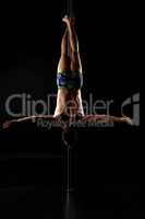 Pole dance. Shot of strong man hanging upside down