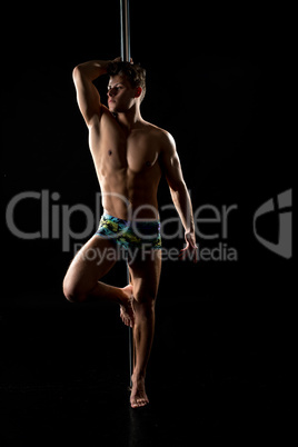 Male pole dance. Photo of muscular man posing