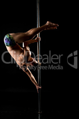 Photo of guy performs acrobatic trick on pole