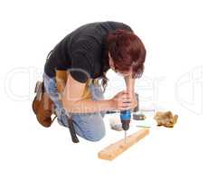 Woman drilling in wood.