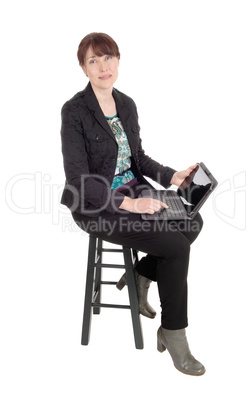 Woman sitting with a laptop on her lap.