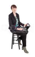 Woman sitting with a laptop on her lap.