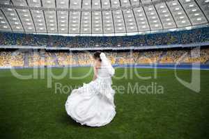 The bride dances on the football field