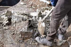 Unknown worker with a shovel clearing construction debris