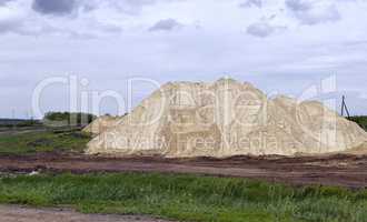 Yellow excavator working digging in sand quarry