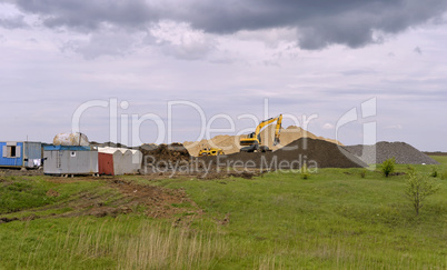 Yellow excavator working digging in sand quarry