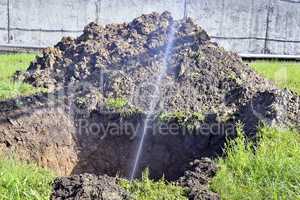 The water jet in the form of leakage in the damaged metal pipe at the production site