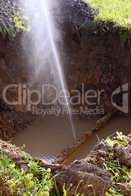 The water jet in the form of leakage in the damaged metal pipe at the production site