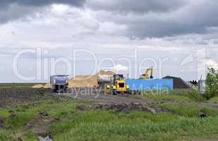 Yellow excavator working digging in sand quarry