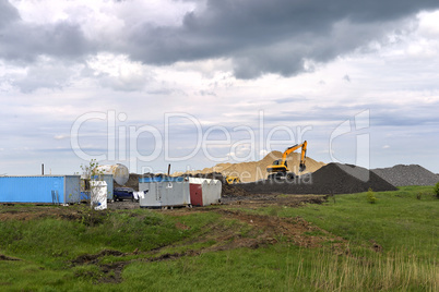 Yellow excavator working digging in sand quarry