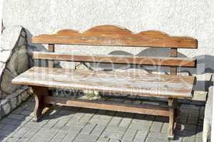 Old wooden vintage empty bench standing on an open paved area