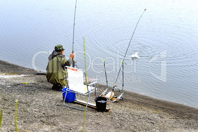 A fisherman with a fishing rod on the river bank