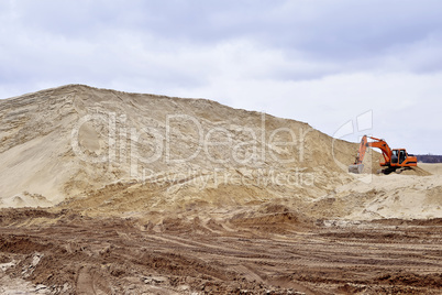 Working digger in a quarry produces sand