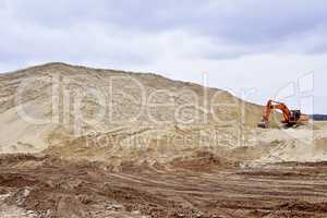 Working digger in a quarry produces sand