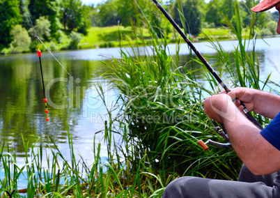 Close up of guy sitting on bridge and fishing