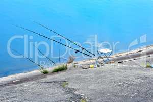 Fishing chair, fishing rods and fishing gear on the lake on a ba