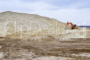 Working digger in a quarry produces sand