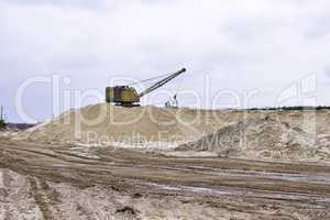 Working digger in a quarry produces sand