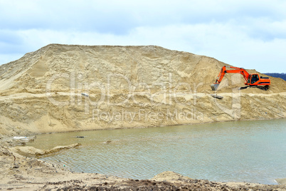 Working digger in a quarry produces sand